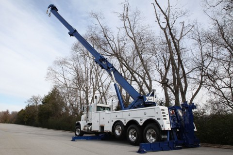 century 1075s rotator with boom extended over cab and outriggers extended