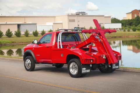 red vulcan 810 intruder wrecker on a ram trucks chassis in front of a pond