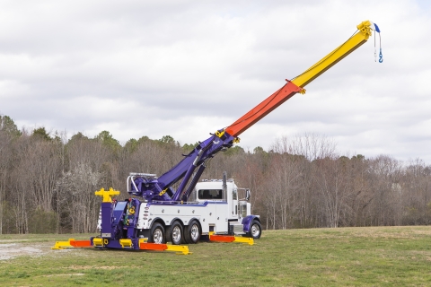 white and purple vulcan 975 rotator with boom and outriggers extended in a field