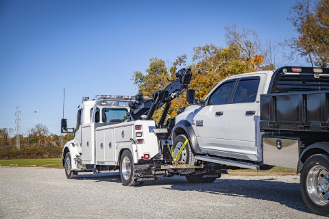 This image shows the redesigned kneeboom style underlift on the 600R towing a utility truck.