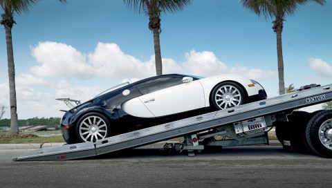 bugatti veyron being loaded onto a gray century 12 series lcg right approach carrier