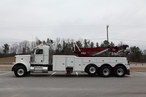 red and white century 1150 rotator on a peterbilt 389 chassis in a parking lot