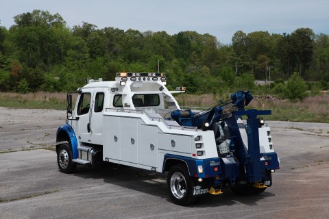 rear side photo of a white and blue vulcan v-30 on a freightliner m2 chassis