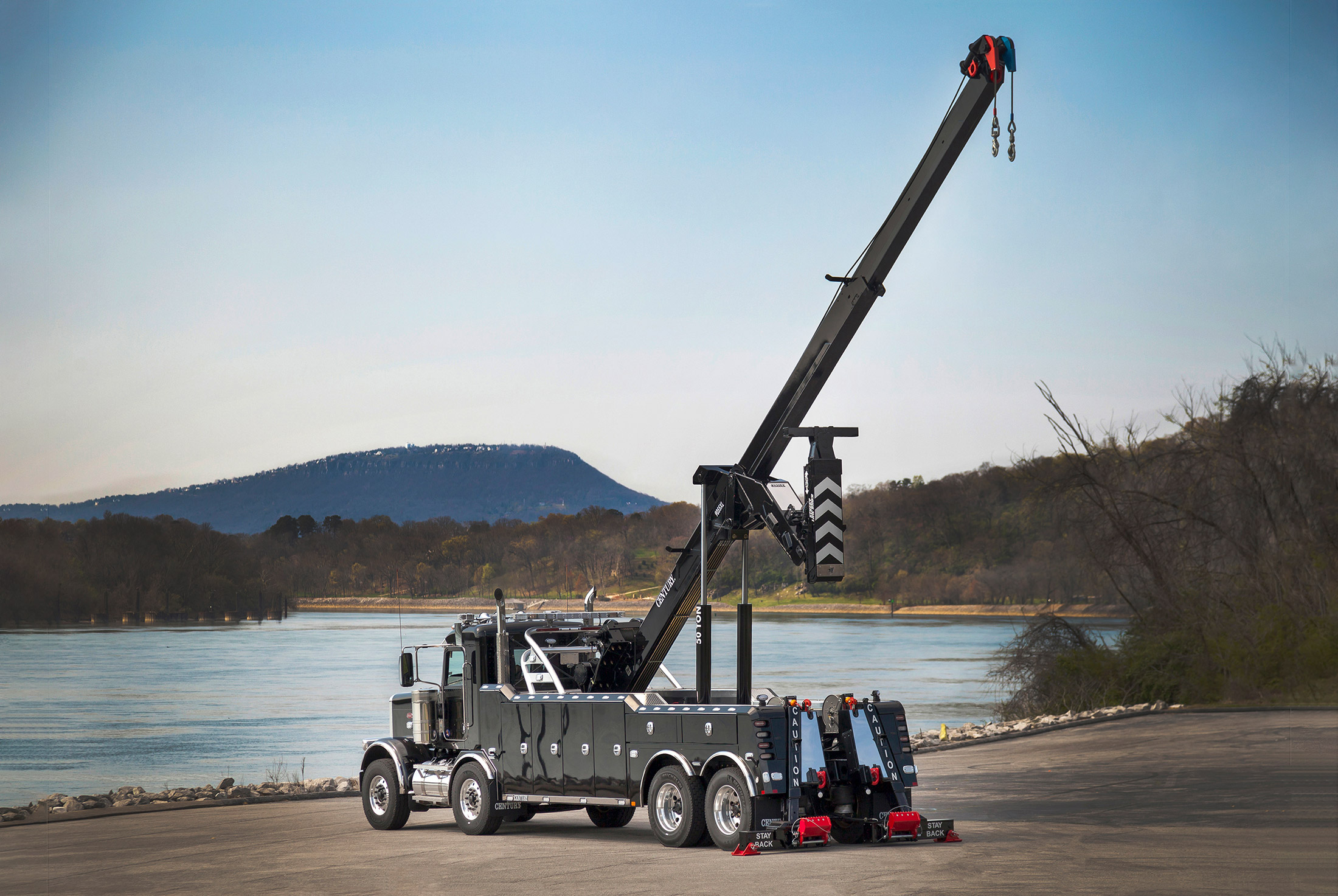 Extended boom of a Century 9055XL on a black Peterbilt 389 tandem tandem chassis