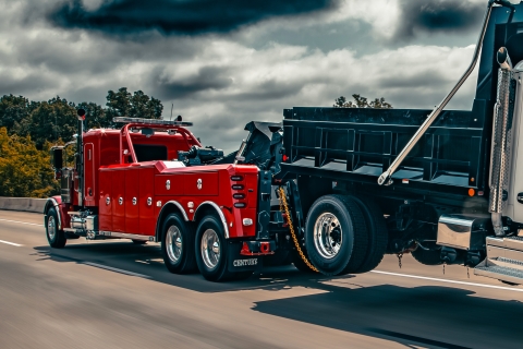 Red Century 5230 on a peterbilt 589 chassis towing a dump truck