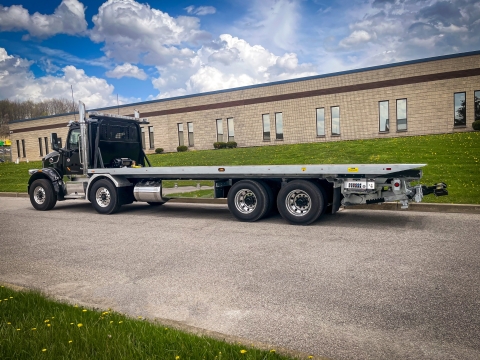 Side view of a 40-Series LCG industrial carrier mounted on a tandem-steer Peterbilt truck chassis.