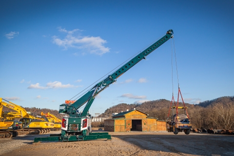 century m100 with boom extended lifting a piece of equipment