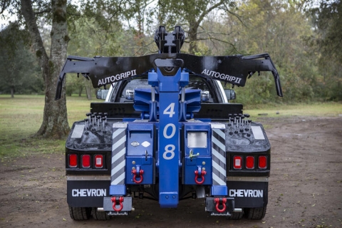 Image shows an AutoGrip two wheellift on the back of a Chevron™️ 408 light-duty autoloader. This wheellift system is manufactured by Miller Industries.