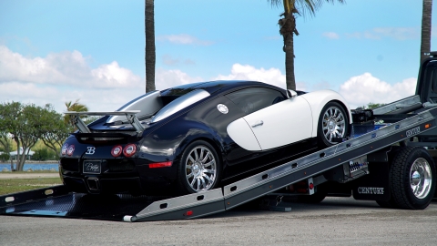 black and white bugatti veyron loaded on a century 12 series carrier with right approach option