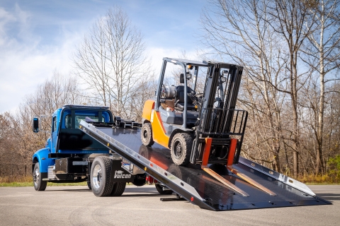 blue Vulcan 16 series lag on a Peterbilt 337 chassis loaded with forklift