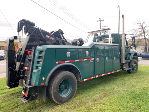 Rear view image of a Century 4024 in army green in muddy environment.