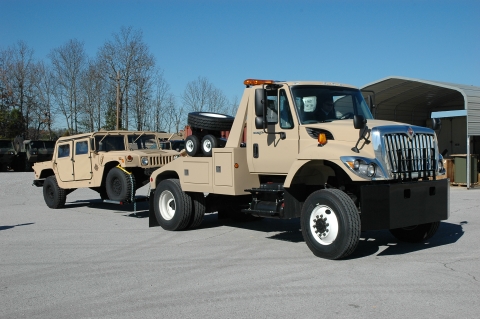 Century Light Duty wrecker towing a military humvee.