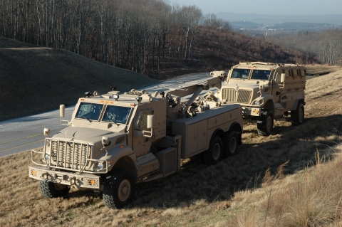 A Century 1135 towing an APC from the front