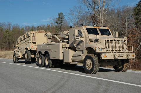 A Century 1135 towing a military APC from the rear