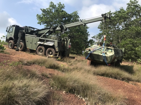 A military Century 1140 rotator recovering an overturned armored military vehicle.