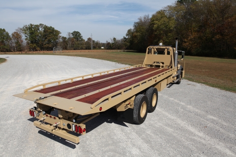Top rear view of a Century heavy-duty carrier showing the tungsten wood plank decking used to transport heavy machinery, ATV vehicles, off-road military equipment, and track-style military combat vehicles.