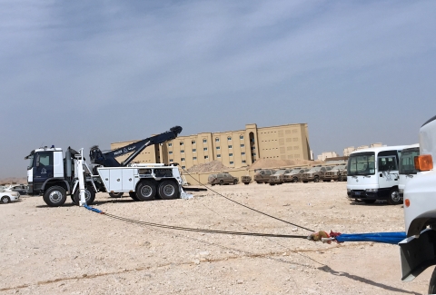 A military police Century 1160 rotator conducting a side winching recovery with a large military truck