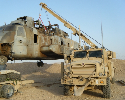 A Century 1135 rotator recovering and lifting a downed CH53 helicopter in a conflict zone