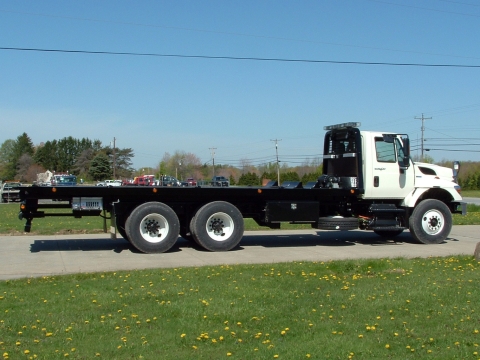 Side view of a Century military carrier in a tandem axle configuration