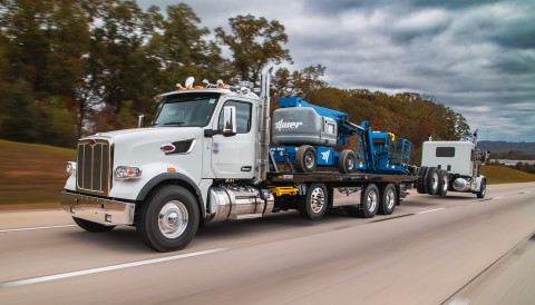 Century 40-Series LCG Industrial Carrier loaded with a manlift and towing a semi tractor