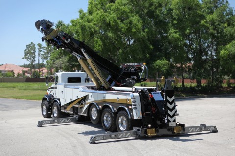 white and black vulcan 975 rotator with boom up and outriggers extended in a parking lot